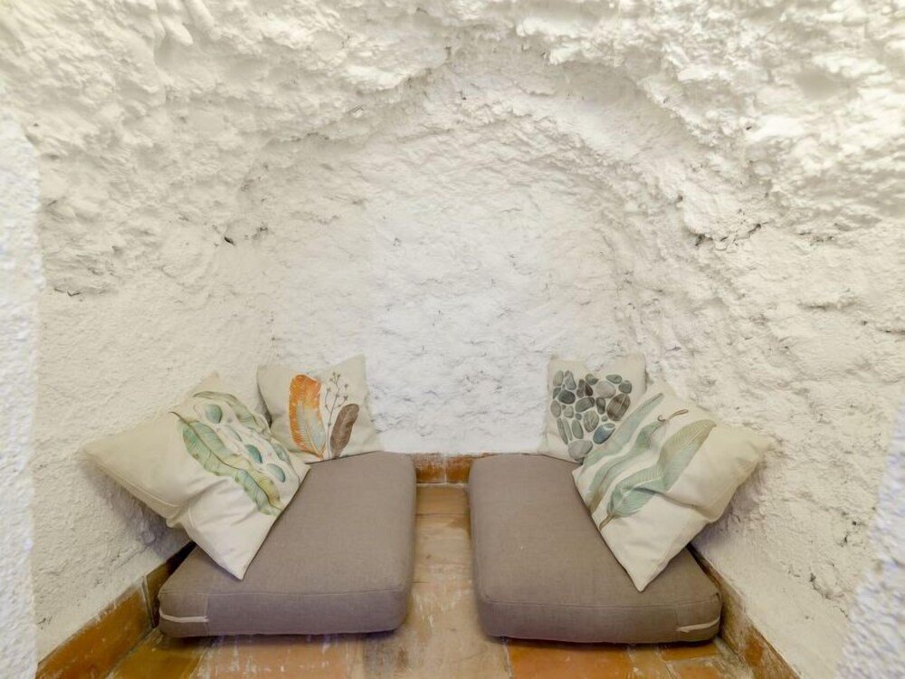 Bedroom with rock walls in Cueva de Lindaraja