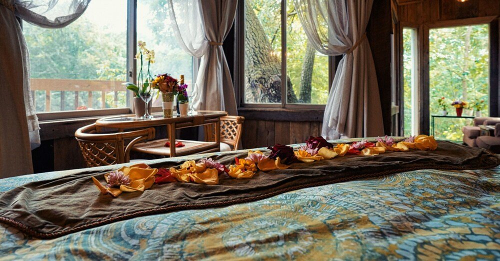 Interior of the treehouse with queen bed and bedding in Tennessee